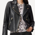 Black leather biker jacket with gold zipper details for women