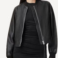 Black leather bomber jacket with modern tailored fit for women.