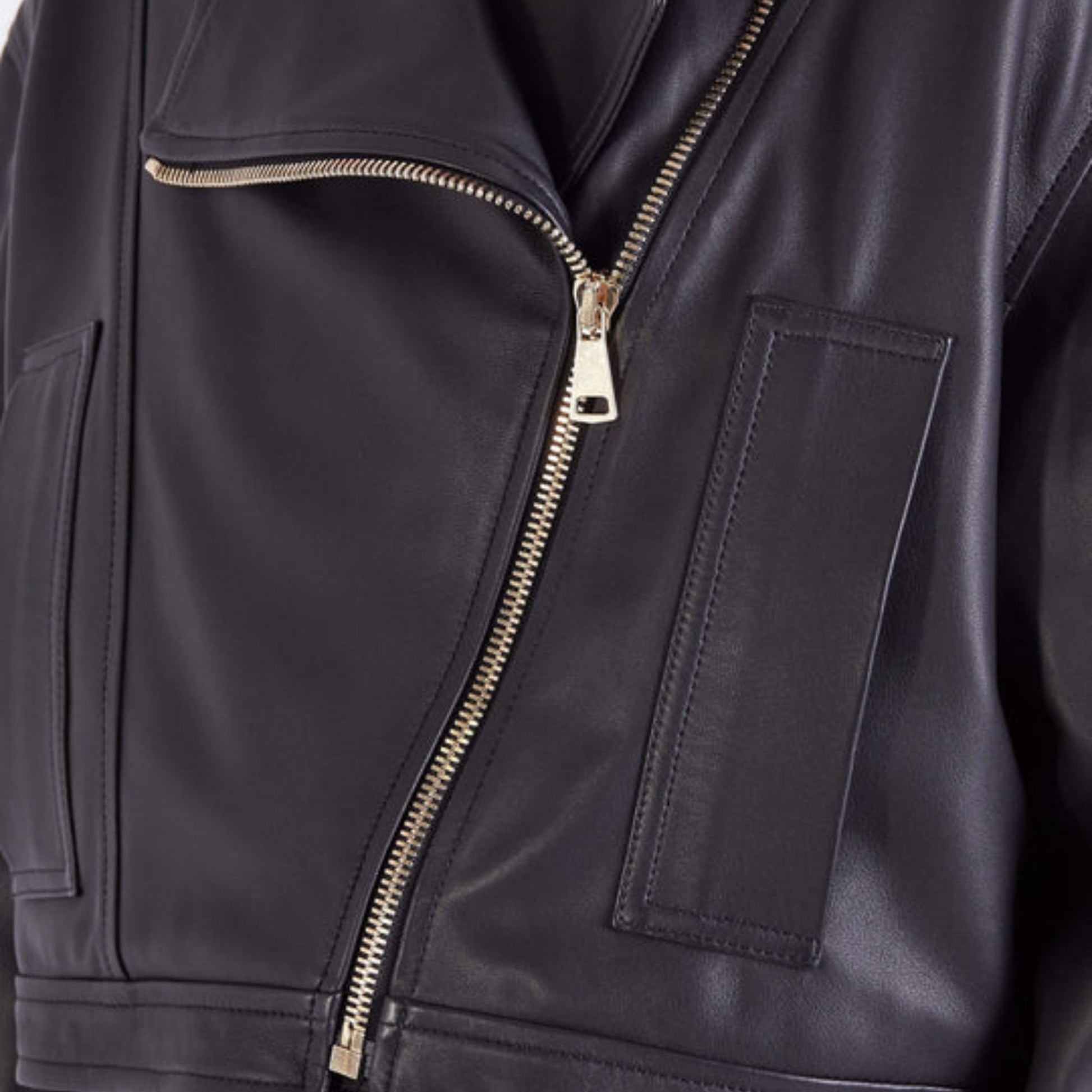 Close-up of premium silver zipper and wide lapel on women's oversized leather biker jacket