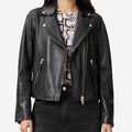 Custom black leather biker jacket with gold hardware finish.